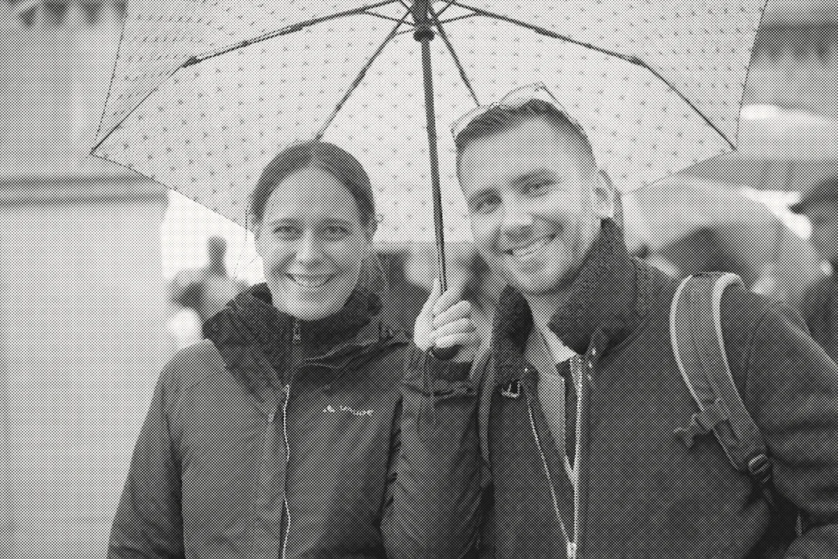 Two colleagues under an umbrella